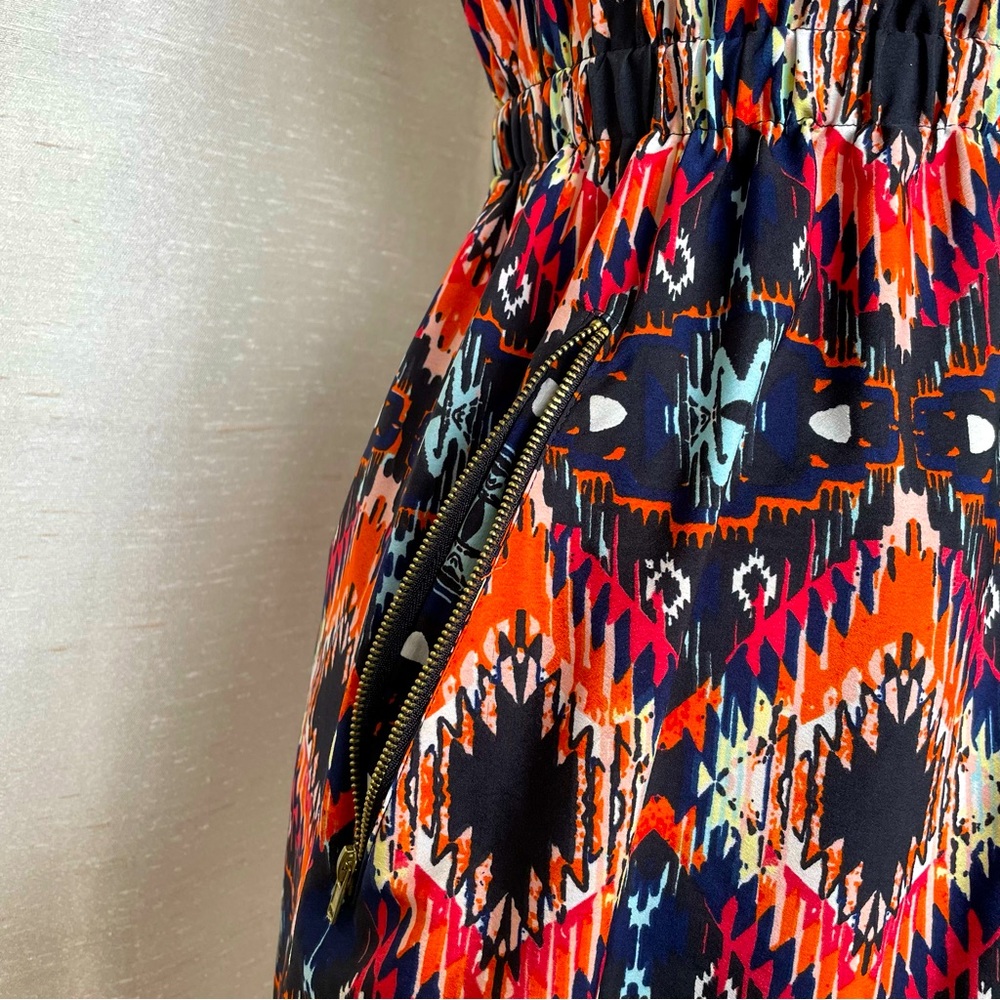 Sleeveless bright patterned dress with cinched waist and zippered pockets